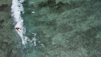Aerial view of a male surfer riding the huge waves