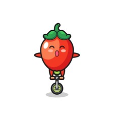 The cute chili pepper character is riding a circus bike