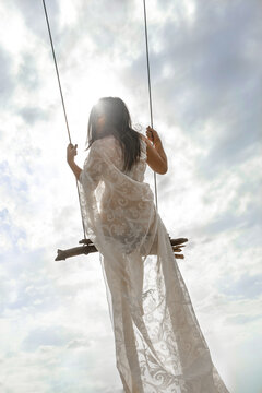 girl on a swing in the clouds