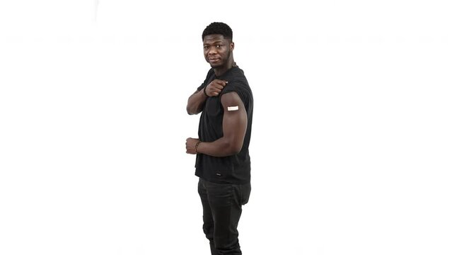 Vertical shot vaccinated black man showing arm white background - full body isolated shot. High quality 4k footage