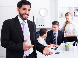 Smiling businessman with professional business team behind during joint work