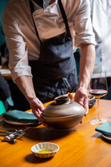 camarero sirve un plato y pan en una mesa de restaurante con copa de vino y platos close-up