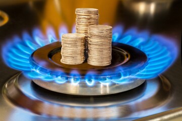 Concept is to increase the cost of supply , payment for gas. Coins stack up on a burning gas burner. - obrazy, fototapety, plakaty