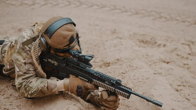 Focused soldier at ground level stance aiming using target scoop . High quality 4k footage