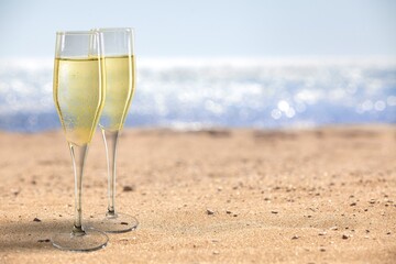 Two Champagne glass on ocean at summer sunset. Tropical travel vacation trip concept