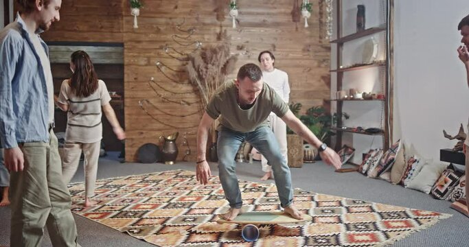 Group of hippie friends partying and doing a balancing act. Group of hippe friends partying with one man doing a balancing act in the centre watched by his mates