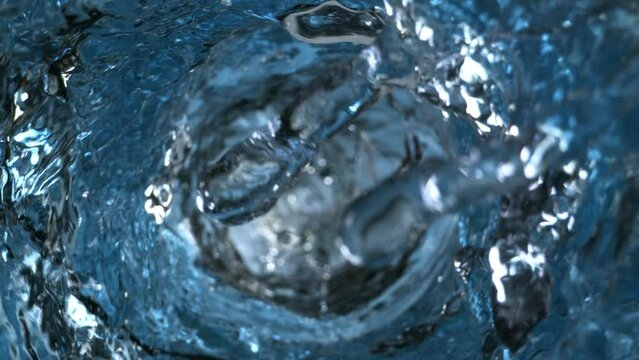 Super Slow Motion Shot of Water Whirling and Splashing in Glass Bottle at 1000fps.