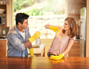 Adding a little fun to their housework. Shot of a young couple messing around while cleaning the...