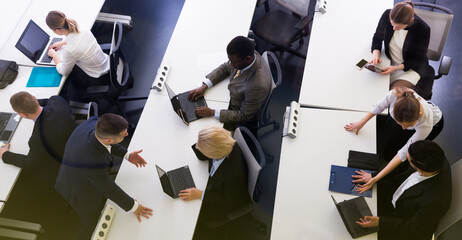 Above view of successful managers engaged in business activities in busy open plan office.