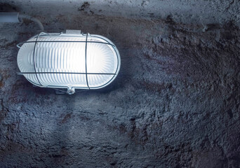 Concrete wall under Industrial old ceiling lamp light. Old vintage basement interior, grunge urban underground background.