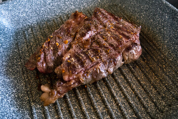 Juicy beef meat steak cooking on griddle pan at professional kitchen. Prime steak frying at grill. Delicious, modern cuisine