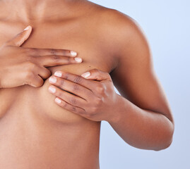 How do you perform a breast self-examination. Studio shot of an unrecognisable woman examining her...