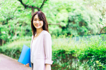 書類を持って歩く若いビジネスウーマン