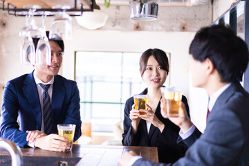 バーでお酒を飲む男女の会社員