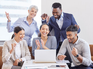 Working independently toward one goal. Shot of a group of colleagues cheering in a office.