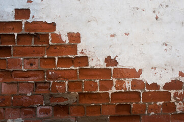 WHite paint on brick. White paint and plaster eroded from a brick wall in an abandonded building.