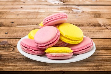 Plate with tasty macaroons on background. Sweet food concept