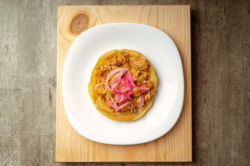 Cochinita Panuchos, gourmet Yucatecan food, on a wooden background