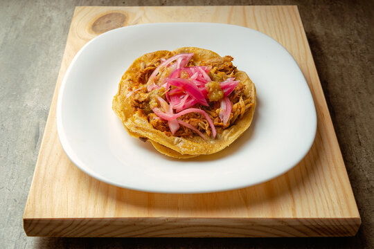 Cochinita Panuchos, gourmet Yucatecan food, on a wooden background