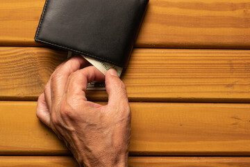 Hand removing a dollar bill from a wallet