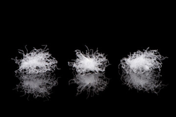 soft fluffy white down feather on black background.