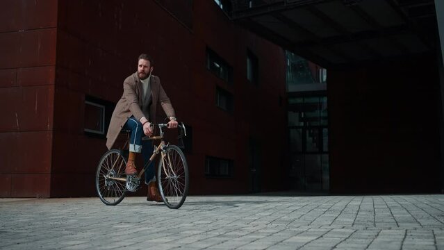  The stylish handsome man stops on a bicycle. Packshot, copyspace, hipster, worker