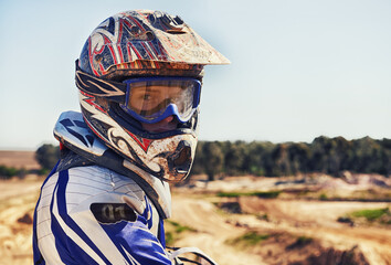 Time to rip up this track. Portrait of motocross rider looking back.