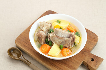 Sop Iga (Beef ribs soup) is Indonesian soup. Made from ribs, carrots, leeks, and potatoes. Served in white bowl. Selected focus
