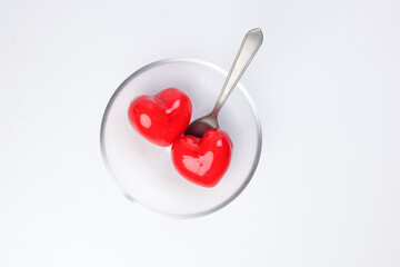 transparent glass bowl spoon with three dimension 3d red hart shape symbol inside on white...