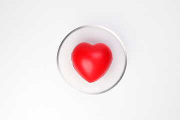 transparent glass bowl with three dimension 3d red hart shape symbol inside on white background copy text space top view
