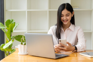portrait of an Asian woman attractive girl sme business owners starts working with laptop happily...