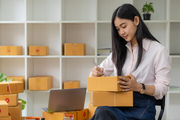 portrait of an Asian woman attractive girl sme business owners starts working with laptop happily...