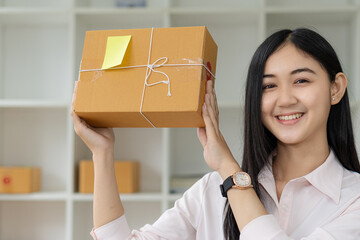 portrait of an Asian woman attractive girl sme business owners starts working with laptop happily...