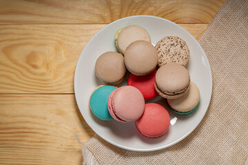 Close up macaron dessert pastel tones on white plate , Sweet and colorful french macaroons  on wooden background, Dessert.