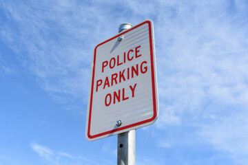 Police Parking Only road sign on pole against blue sky