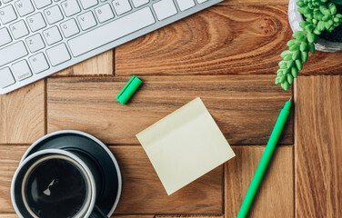 Office desk with light yellow stickers, coffee and laptop.