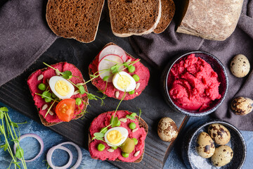 Board with pieces of bread and tasty hummus on color background