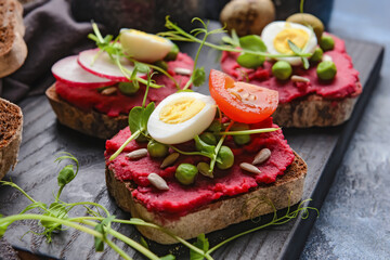 Board with pieces of bread and tasty hummus, closeup