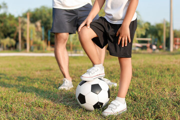 Little boy with soccer ball on field