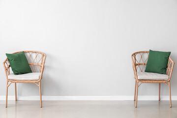Wicker chairs near light wall in room