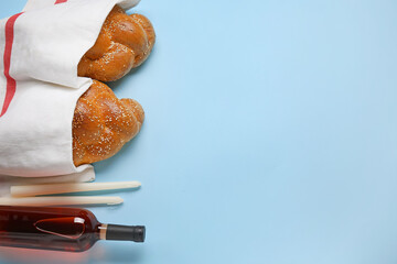 Traditional challah bread with bottle of wine and candles on color background. Shabbat Shalom