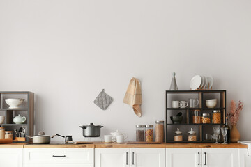 White counters with shelving units and food near light wall