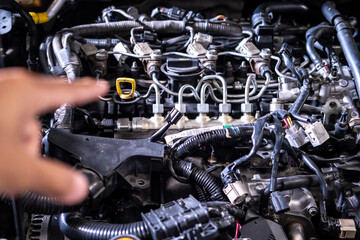 Fototapeta premium Engine car service mechanic maintenance inspection service maintenance car Check engine oil level car in garage showroom dealership blurred background.