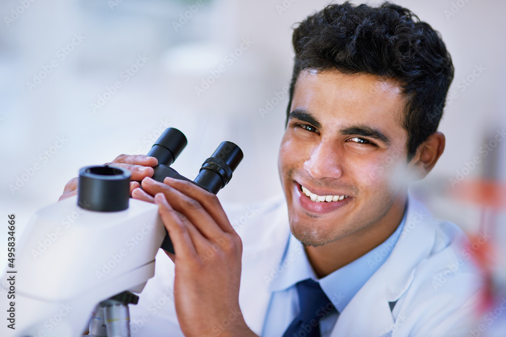 Poster I think Im on to something.... Portrait of a smiling lab technician using a microscope while sitting in a lab.