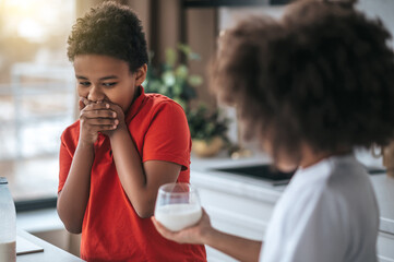 A boy in red shirt refusing from milk