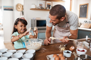 If you dont get your hands dirty, its not fun. Cropped shot of a young man baking at home with his young daughter.