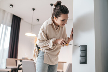 A young woman checking the power socket and looking involved