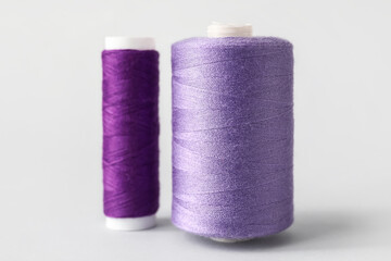 Purple sewing thread spools on light background