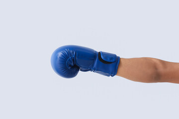 Young man with boxing glove on light background. Immunity concept