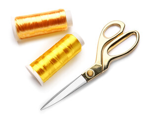 Thread spools and scissors on white background
